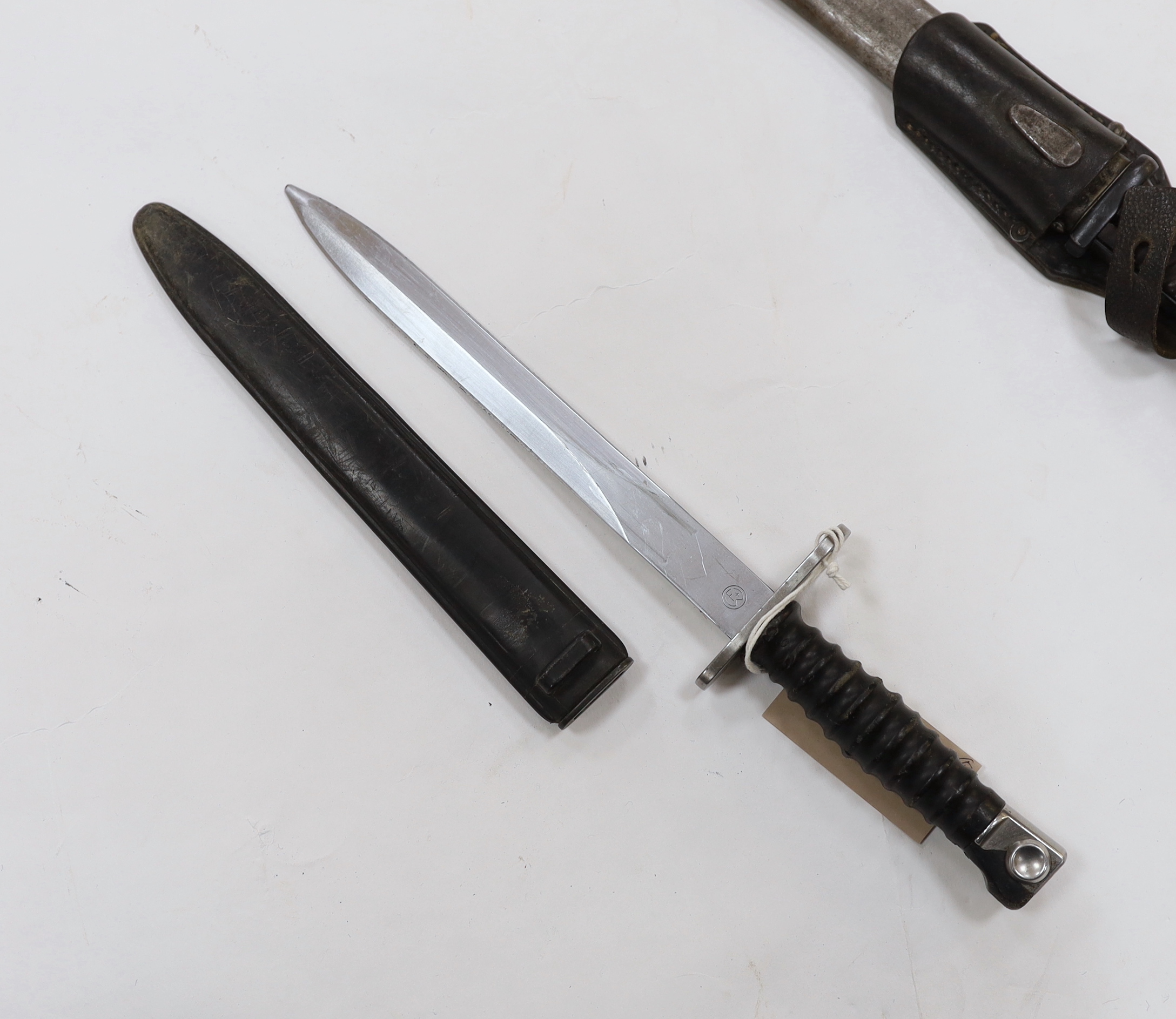 Four bayonets; two Mauser bayonets in scabbards, an American M8A1 carbine bayonet in a scabbard, and another